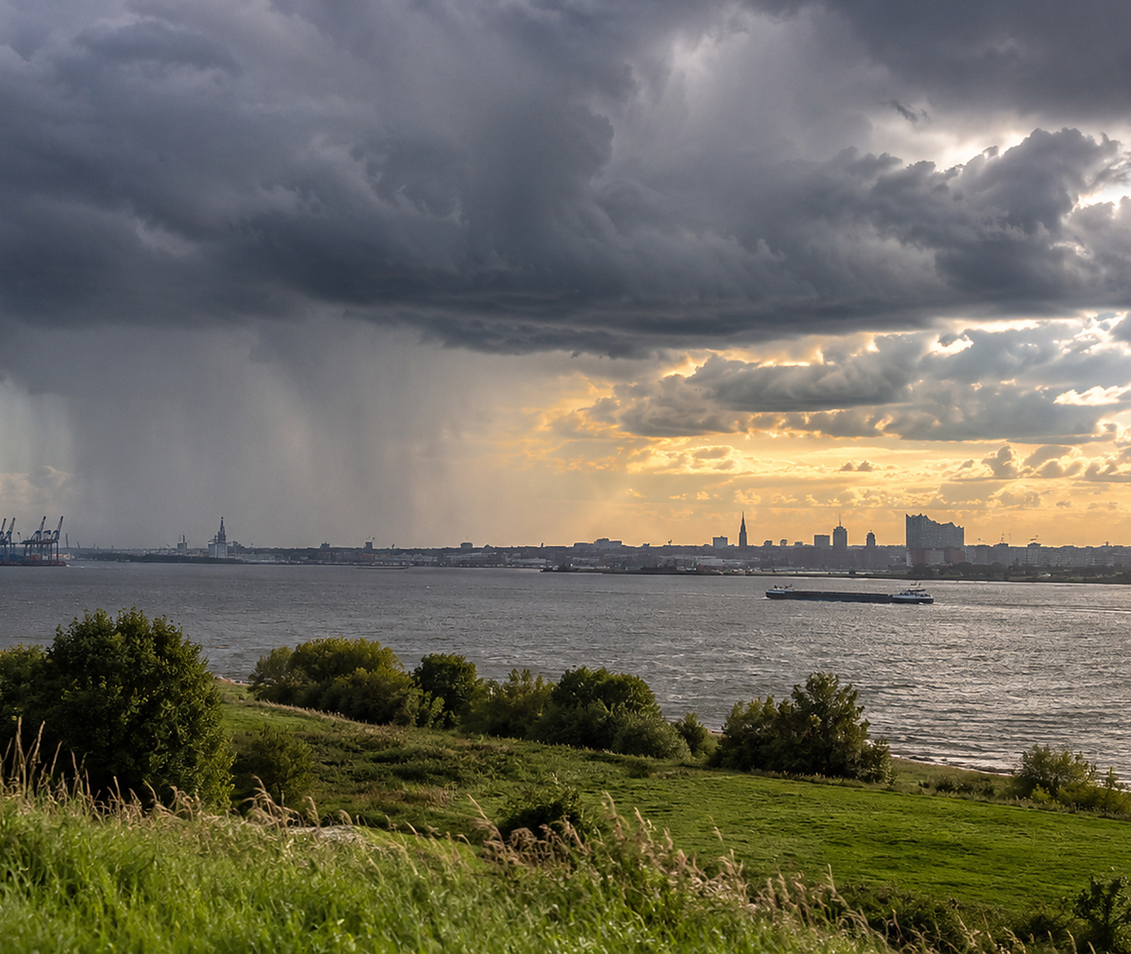 Realistische Wetteraufnahme mit dunklen Schauerwolken, Regen und Auflockerungen über Norddeutschland am 18. September 2026