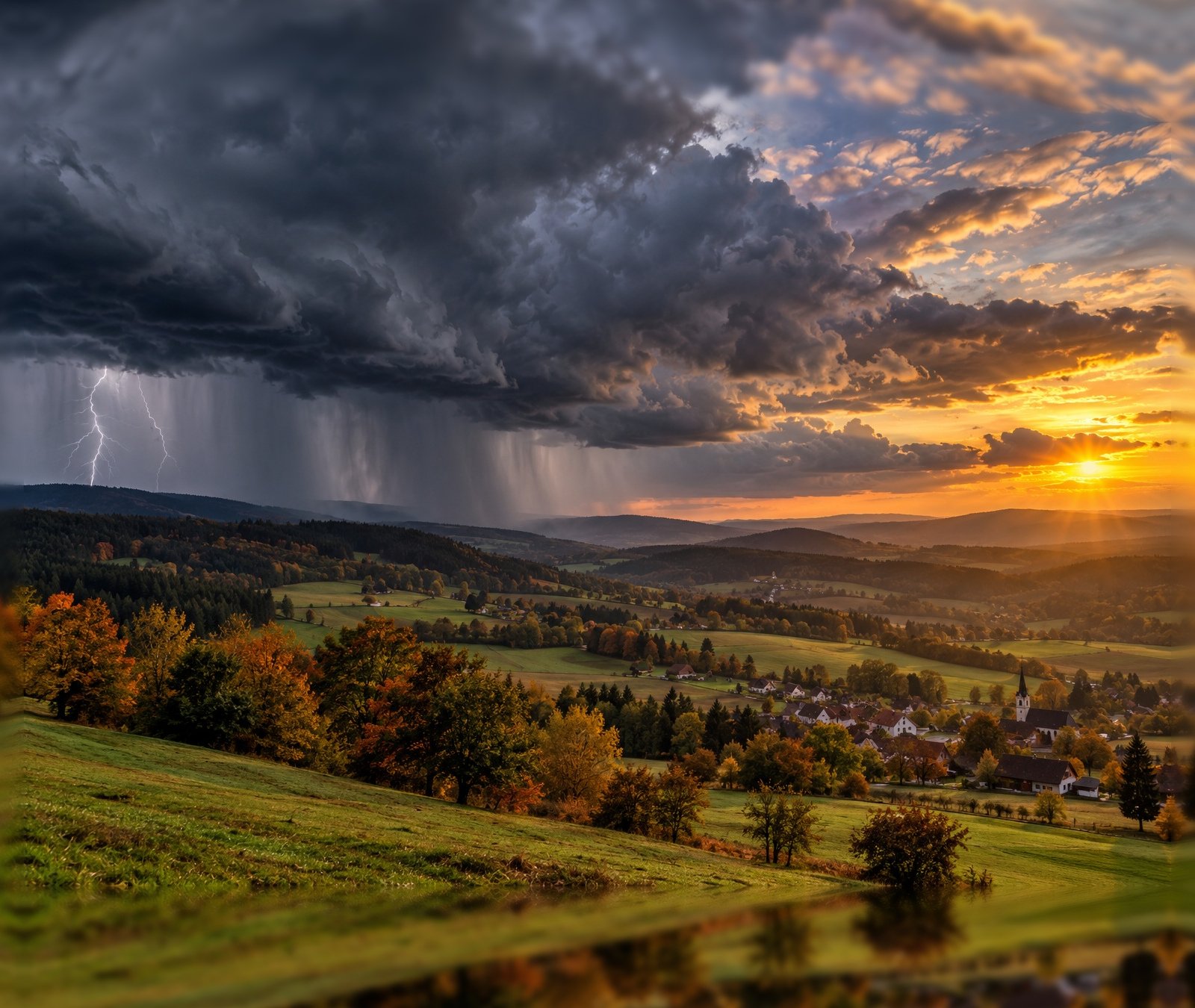 Deutsche Herbstlandschaft mit heranziehender dunkler Gewitterfront und sonnigen Aufhellungen