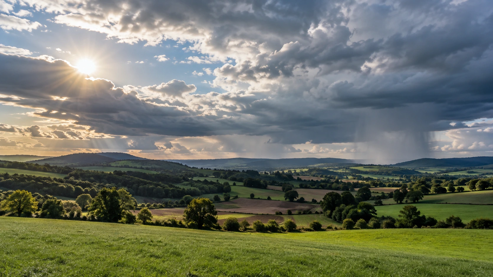 Deutsche Landschaft unter Sonne, Wolken und einem entfernten Regenschauer.