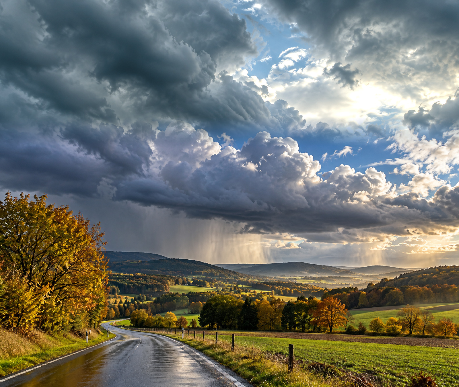 Symbolbild für windiges und regnerisches Herbstwetter in Deutschland mit nasser Landstrasse